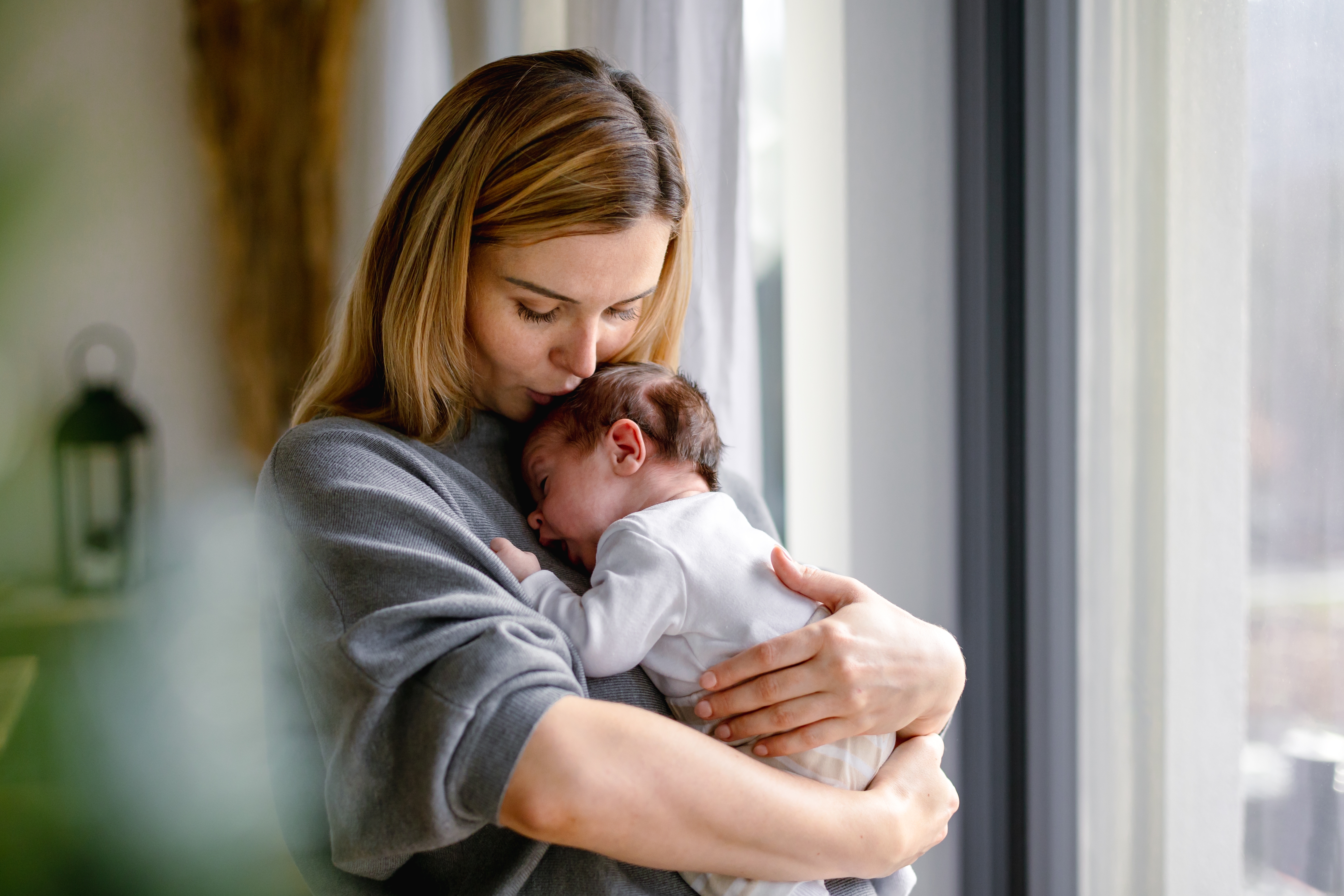 A woman holding a newborn baby | Source: Shutterstock