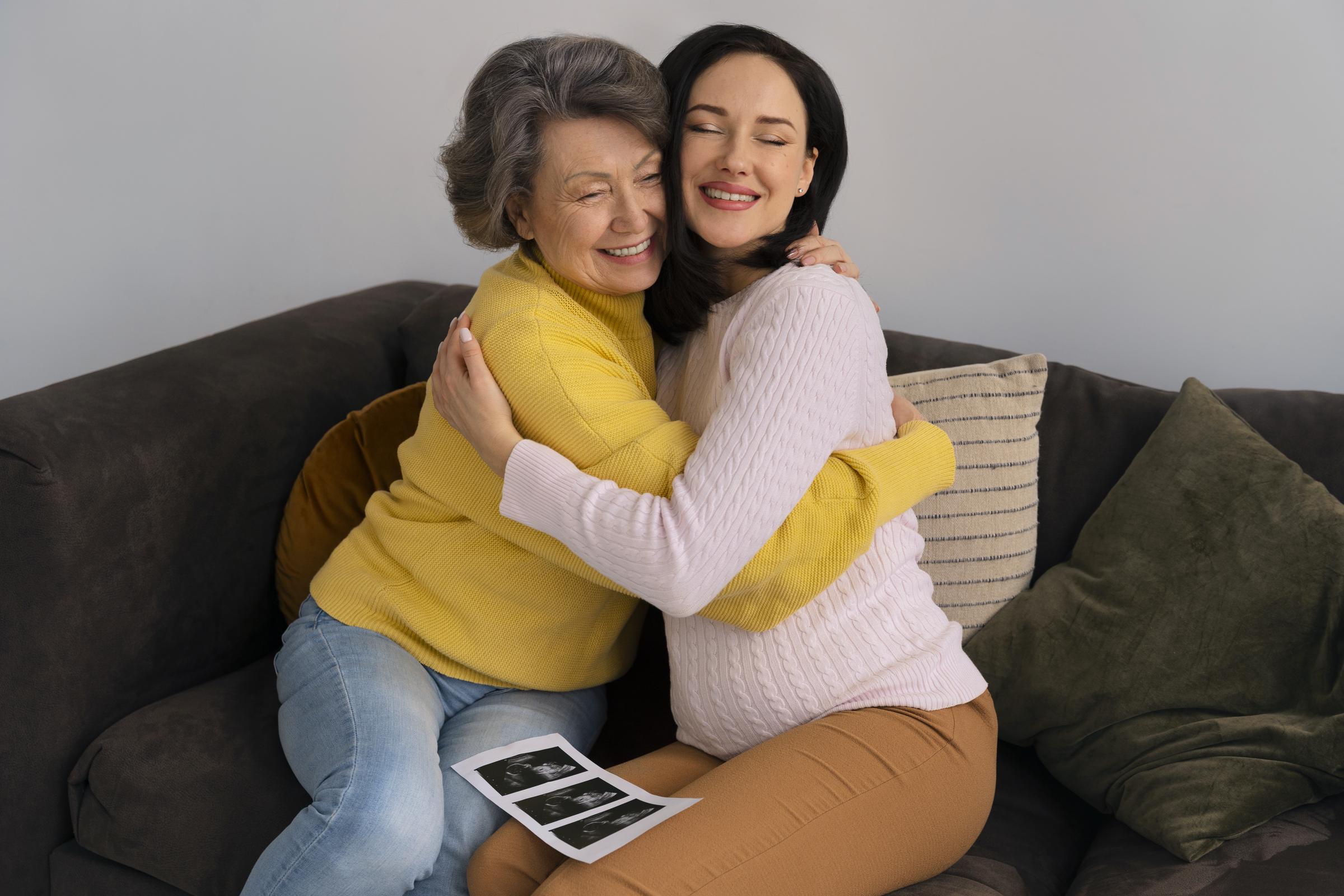 An elderly woman hugging a pregnant young woman | Source: Freepik