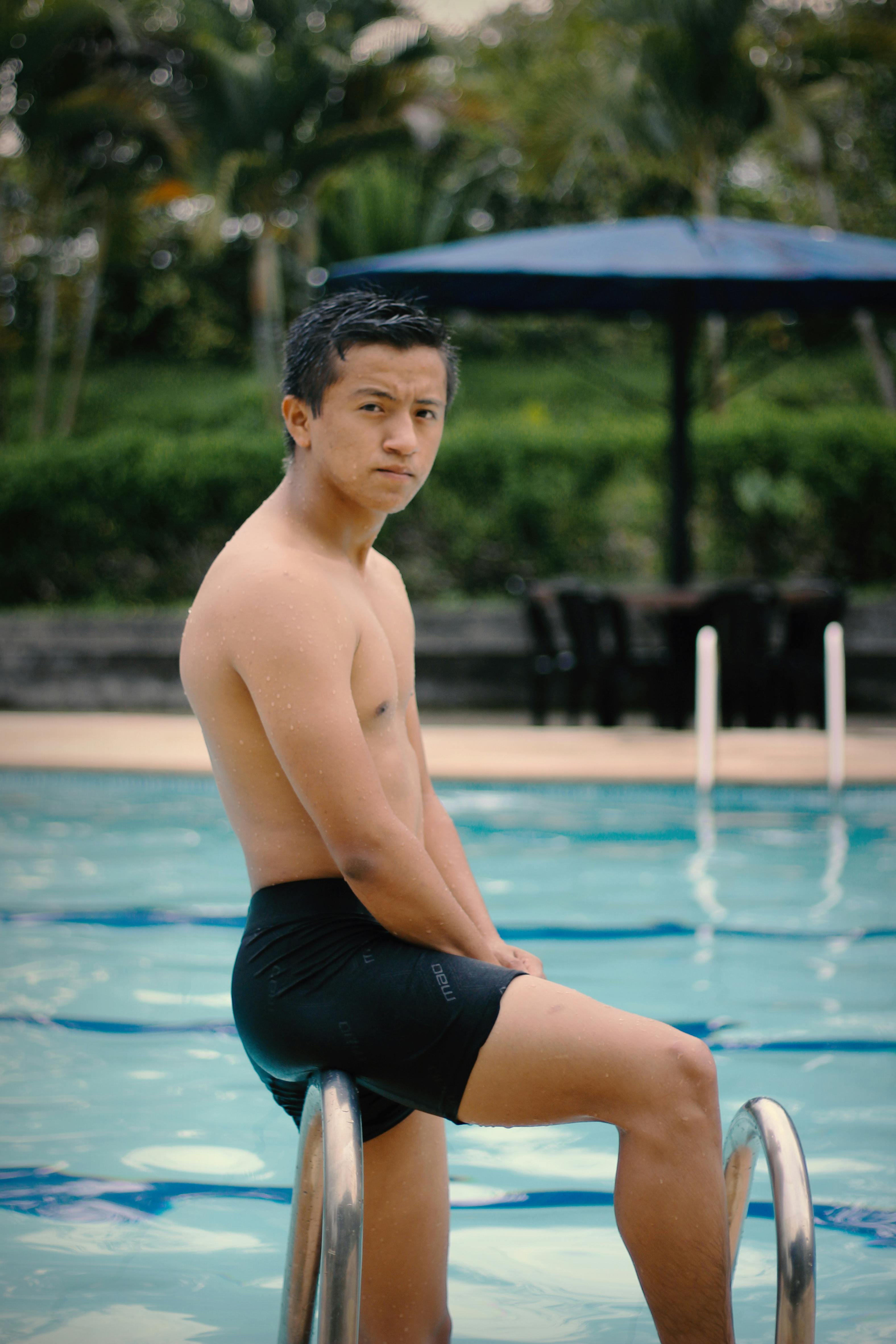 A remorseful-looking man standing by the pool stairs | Source: Pexels